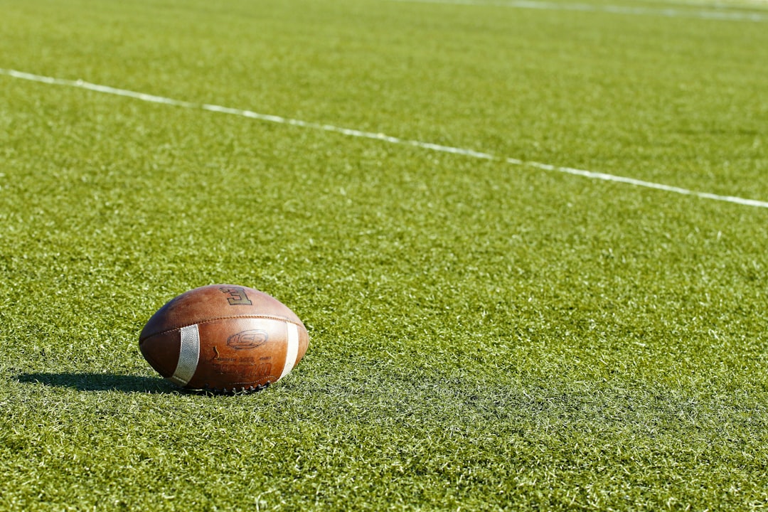 football on green field during daytime wide receiver catch, nfl sideline play, contested football pass