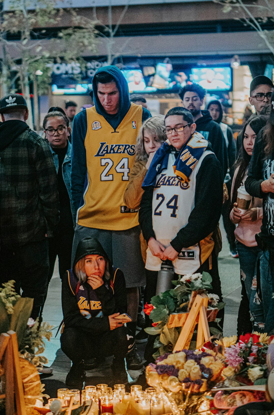 man in blue and white nike jersey shirt standing beside woman in black jacket anthony davis standing full body, basketball court background, los angeles lakers uniform