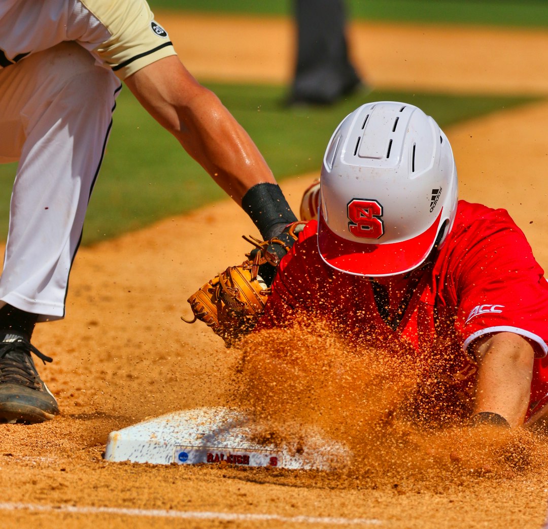 man in white and red jersey shirt and white pants playing baseball during daytime baseball diving catch, infield double play, close play at first base