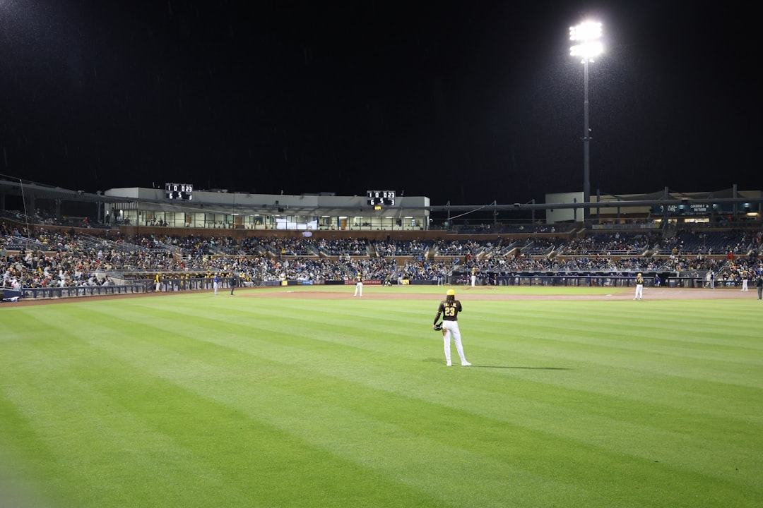 A baseball game is taking place at night. baseball pitcher throwing fastball, close up mound action, stadium lights night game