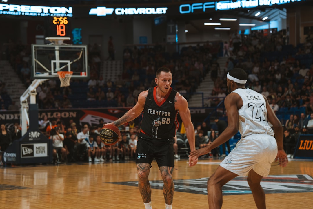 A basketball player dribbles the ball on the court. nba fourth quarter action, intense defense, close basketball game