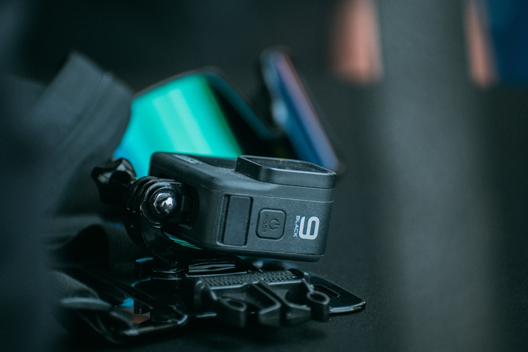 a camera sitting on top of a black table helmet side light mount, secure sports attachment, adjustable bracket close up