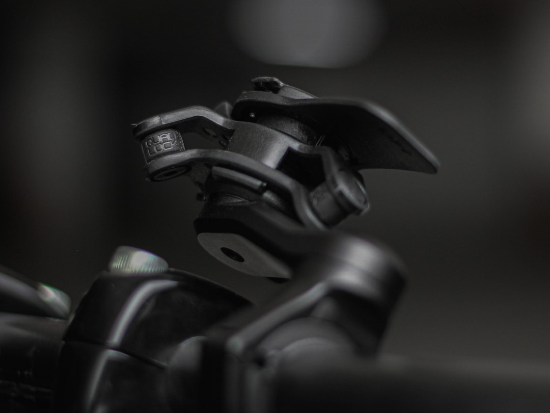 a close up of a bike handle with a blurry background helmet side light mount, secure sports attachment, adjustable bracket close up