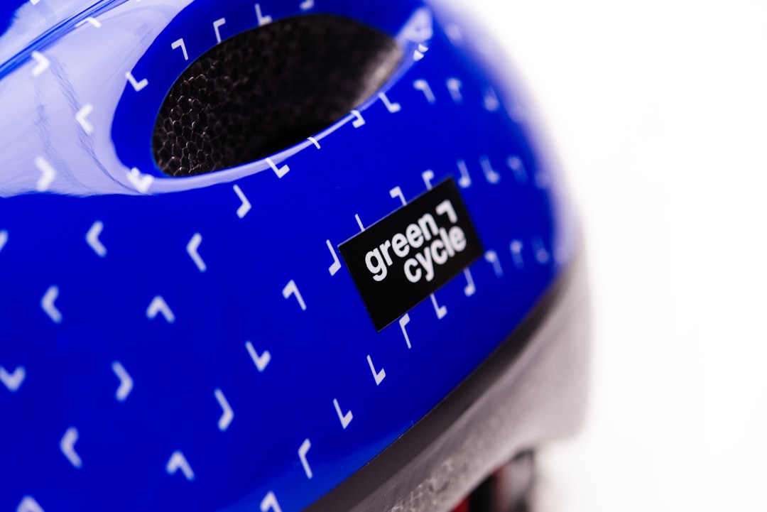 a close up of a blue helmet with white letters helmet top mount placement, masking tape positioning, cycling helmet setup