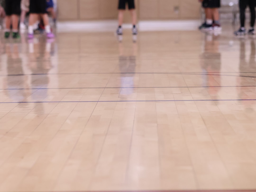 a group of people standing on top of a basketball court racquetball rally action, player hitting ball, indoor court motion, fast swing