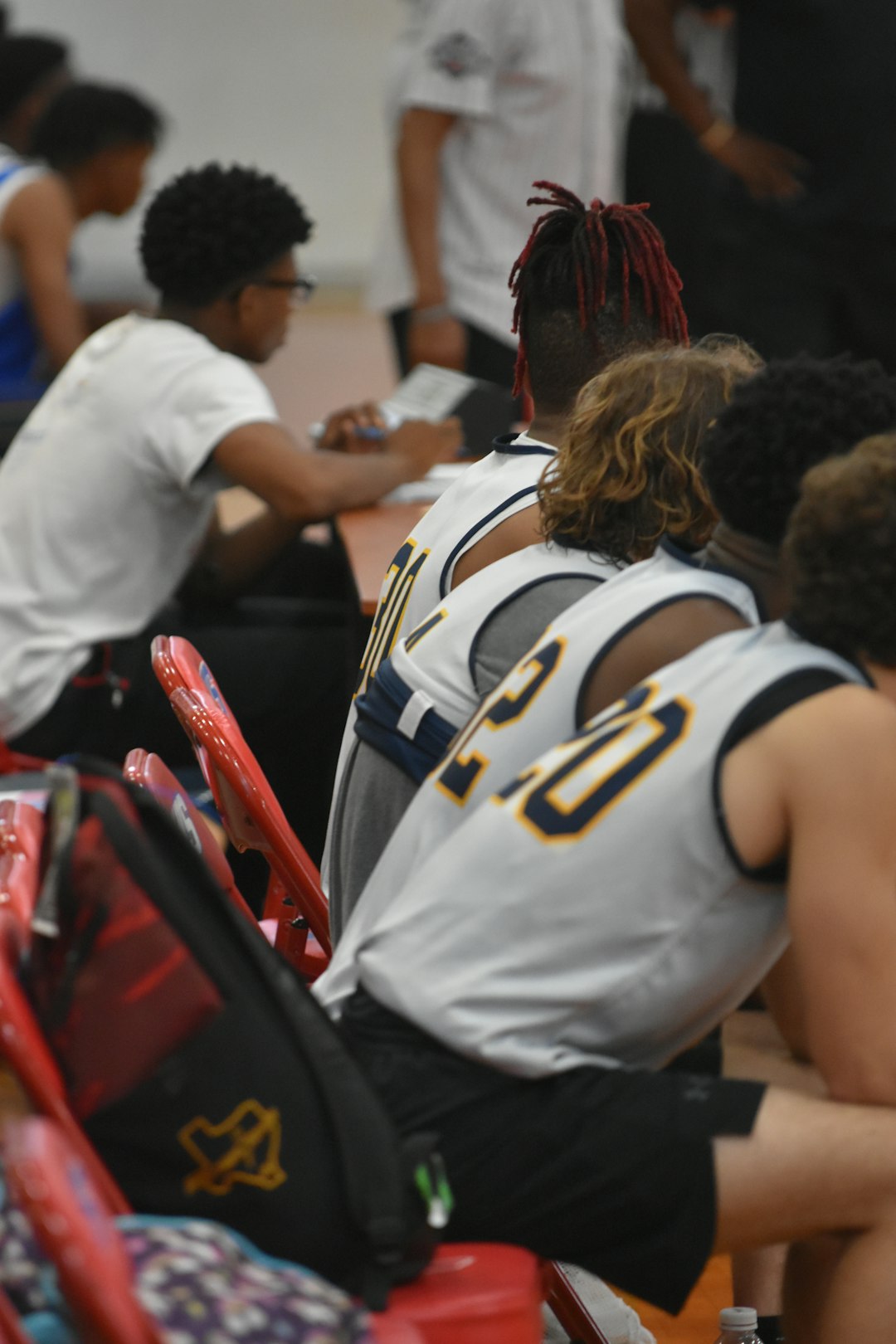 a group of young men sitting next to each other rookie player coach bench sideline