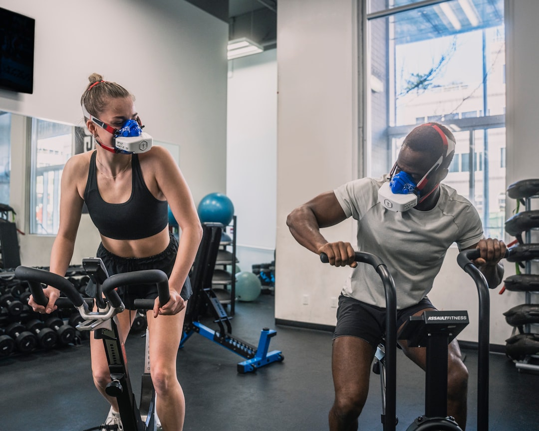 a man and a woman in a gym professional athlete training with wearable sensors, motion analysis screen, modern gym environment