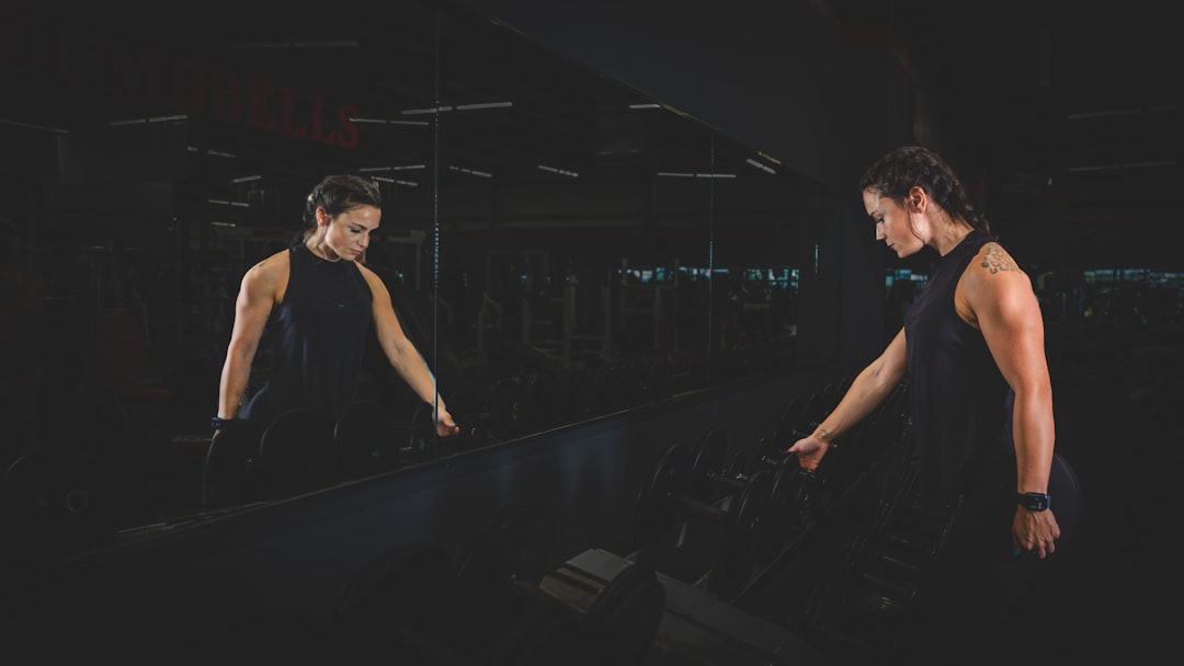 a man and a woman standing in front of a mirror professional athlete training with wearable sensors, motion analysis screen, modern gym environment