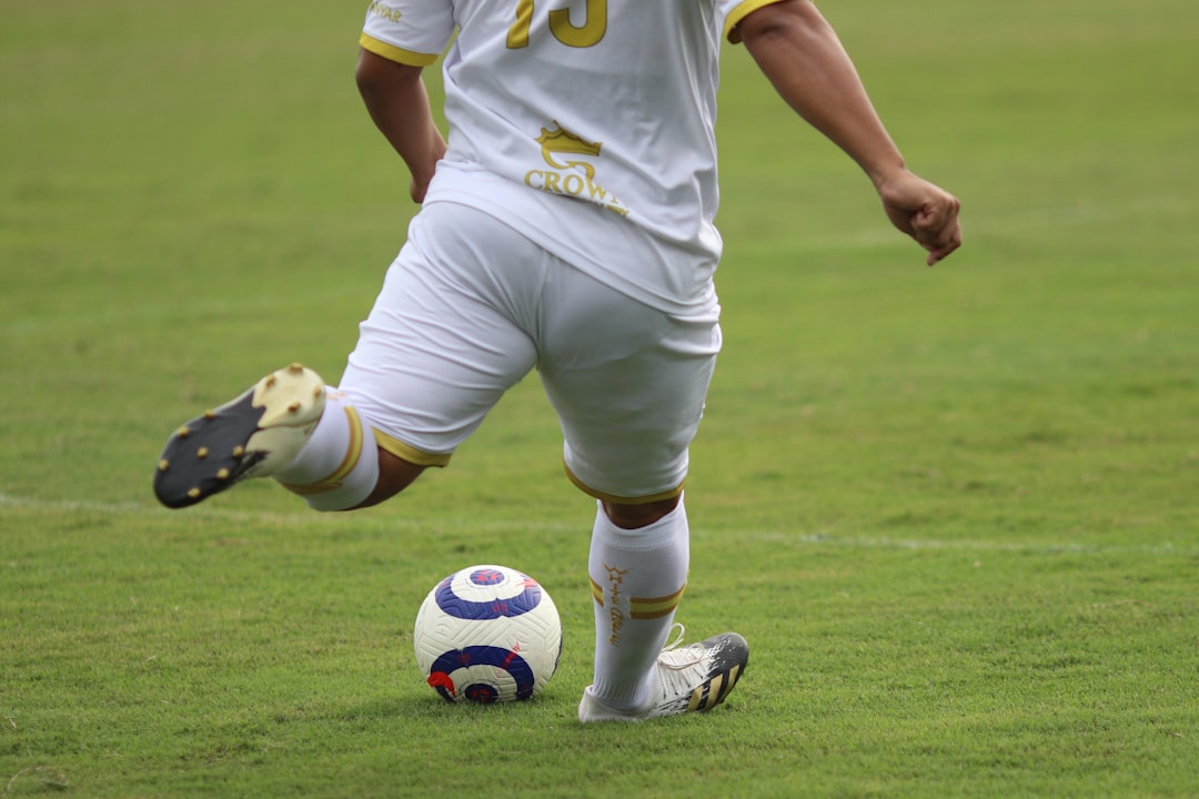 a man in a uniform kicking a soccer ball youth soccer match action, kid kicking ball, adidas x cleats, fast movement