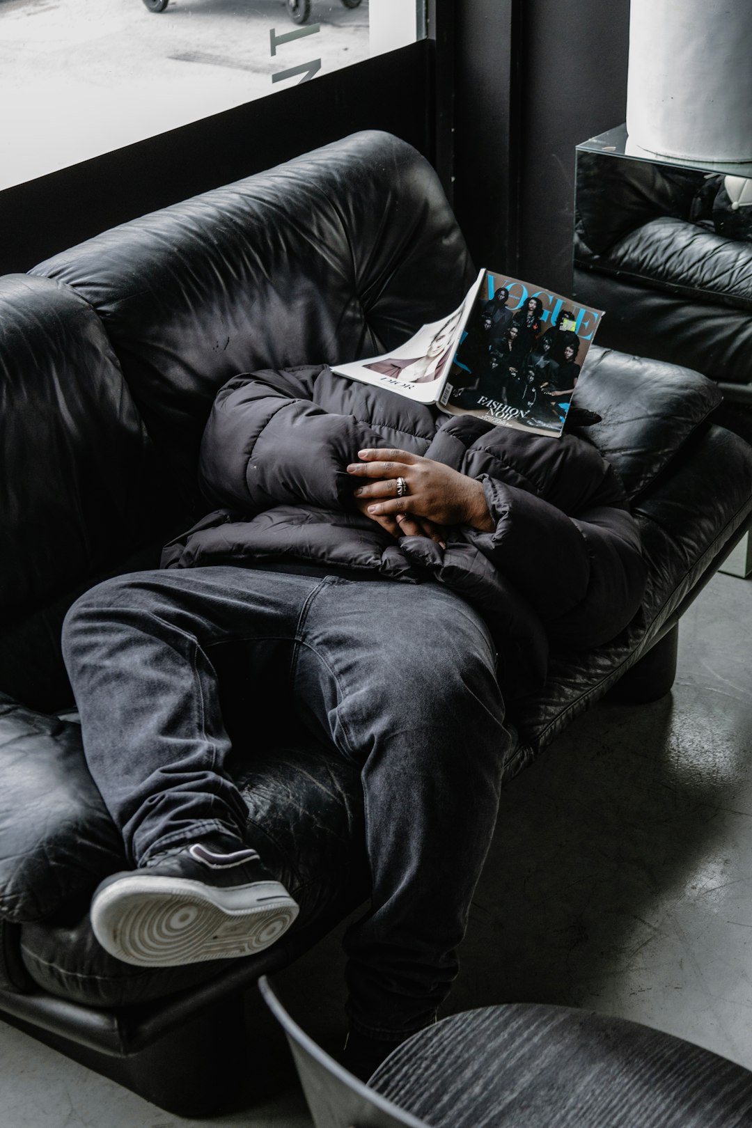 a man laying on a couch reading a book athlete resting on couch, relaxed muscles, post workout fatigue