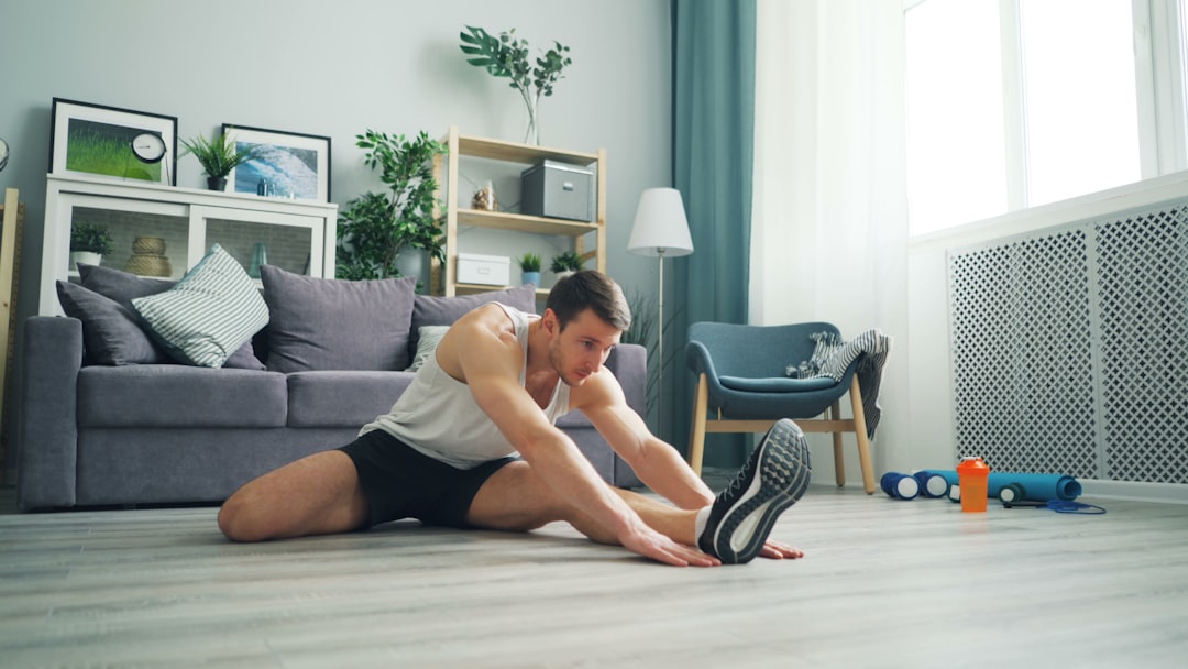 a man sitting on the floor with a pair of shoes sports recovery session, athlete stretching with data overlay, digital performance dashboard