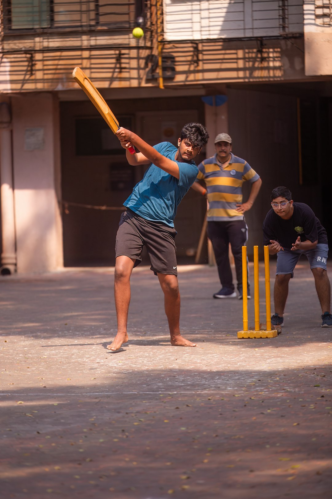 a man swinging a bat at a ball friends playing cricket, cricket practice nets, community cricket match