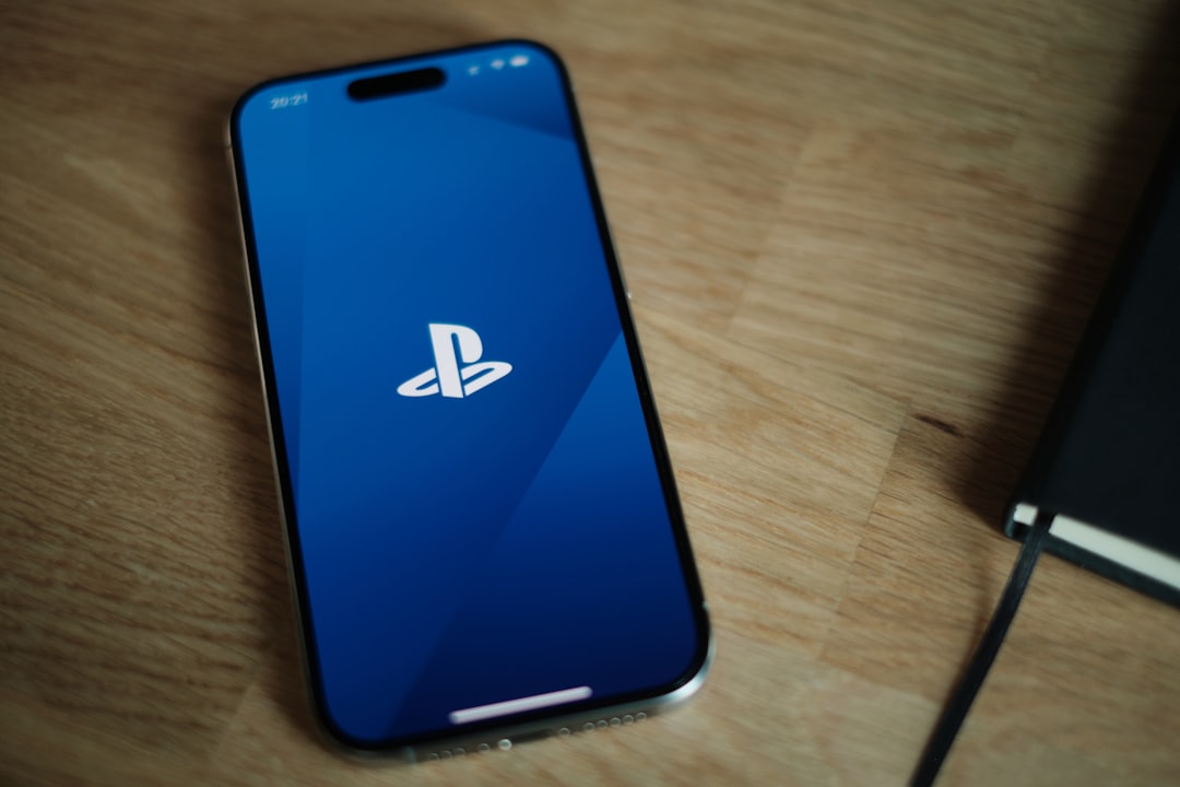 A sony phone sitting on a table next to a game controller playstation network status page, server outage message, maintenance notice