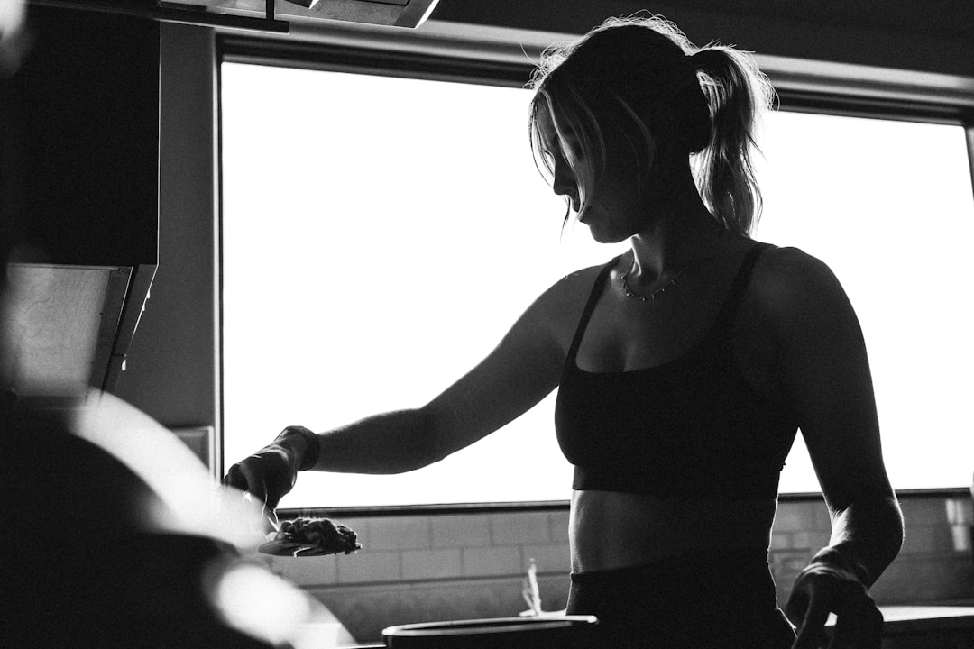 A woman standing in a kitchen next to a window professional athlete training with wearable sensors, motion analysis screen, modern gym environment
