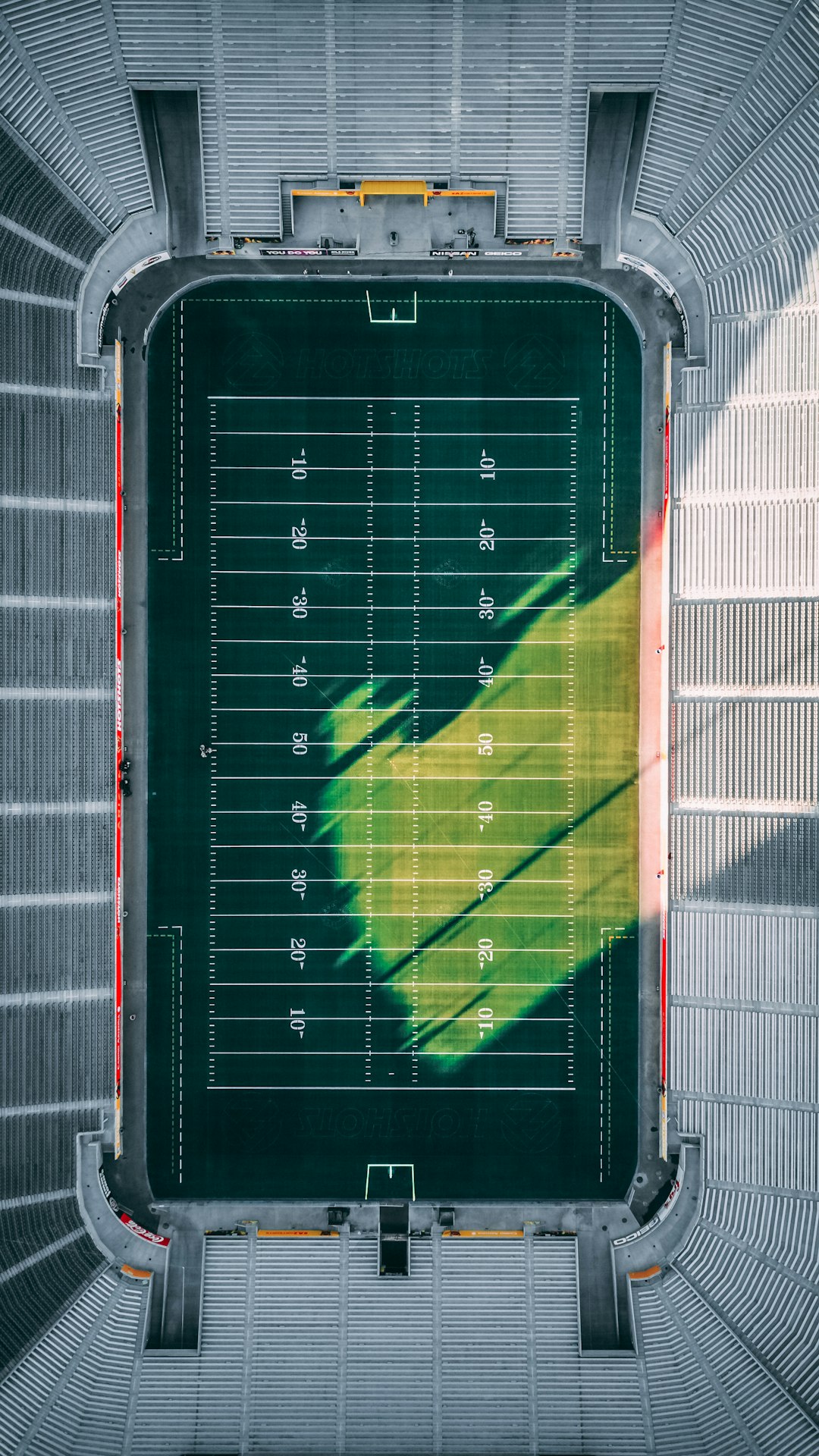 aerial photo of football field during daytime american football field aerial view, marked yard lines, green turf