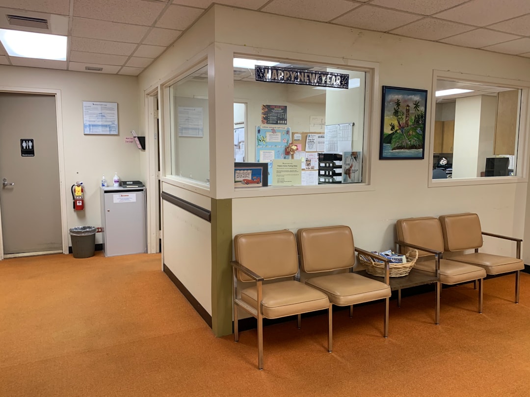 brown and white padded armchairs urgent care waiting room, families waiting, busy clinic summer