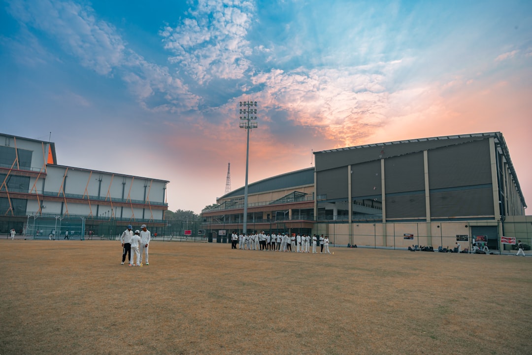 Cricket stadium with players on field at sunset bodyweight squats, push ups, cricket practice ground