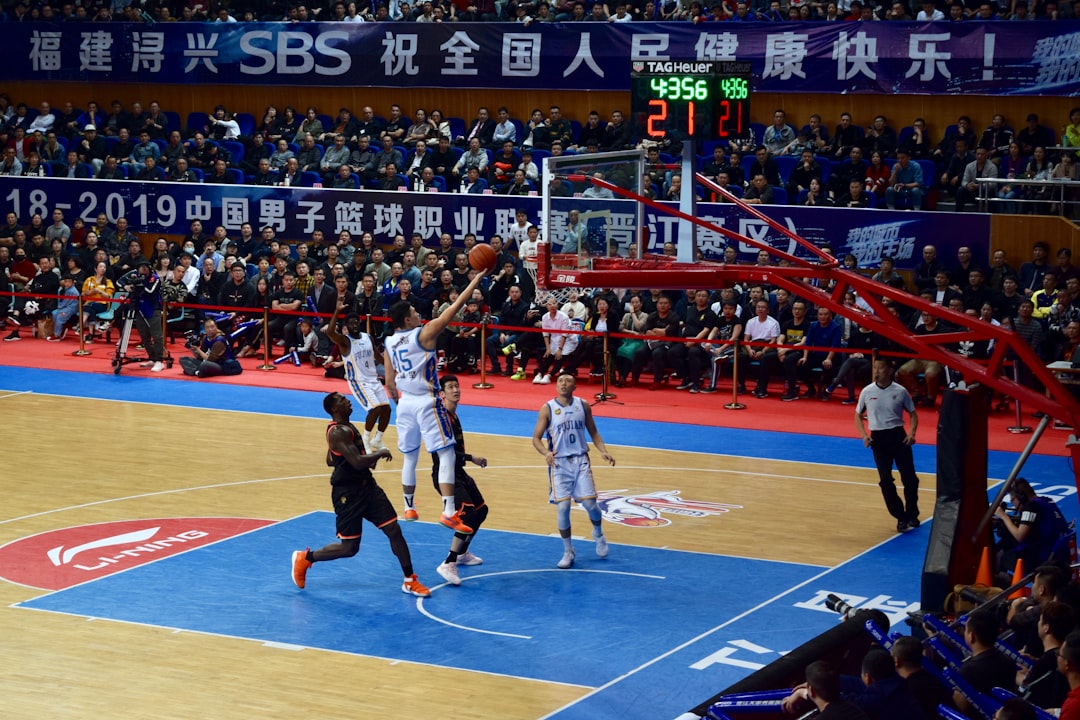 men playing basketball game surrounded with people watching nba fourth quarter action, intense defense, close basketball game