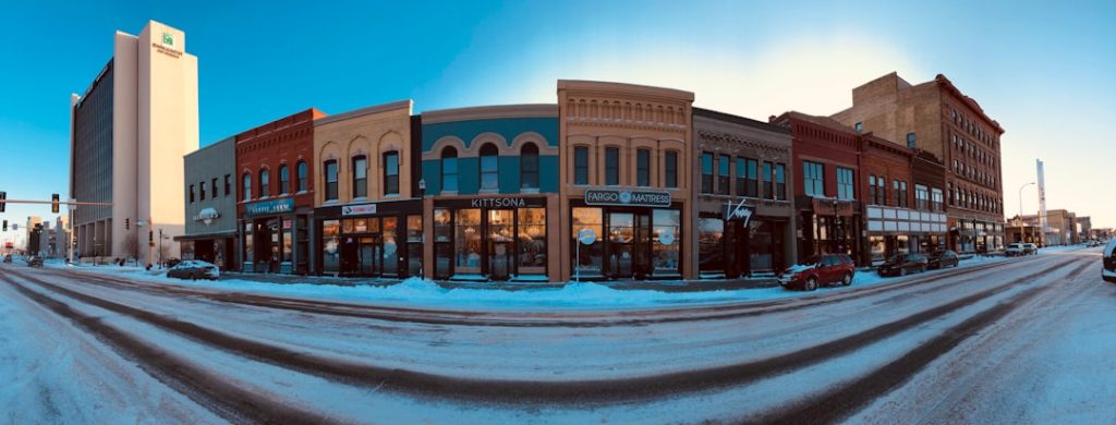 panoramic photography of a brown concrete building front North Dakota snowstorm, winter stadium, blowing snow, dramatic sky