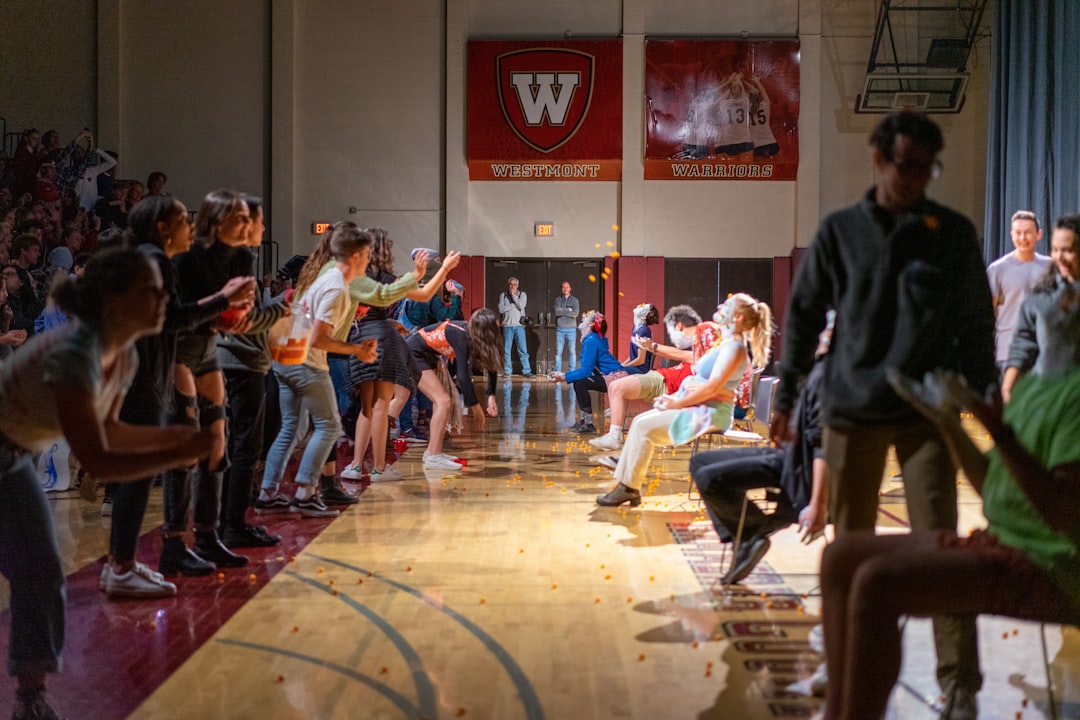 people sitting on brown wooden bench high school gym, student athletes line, school physical event