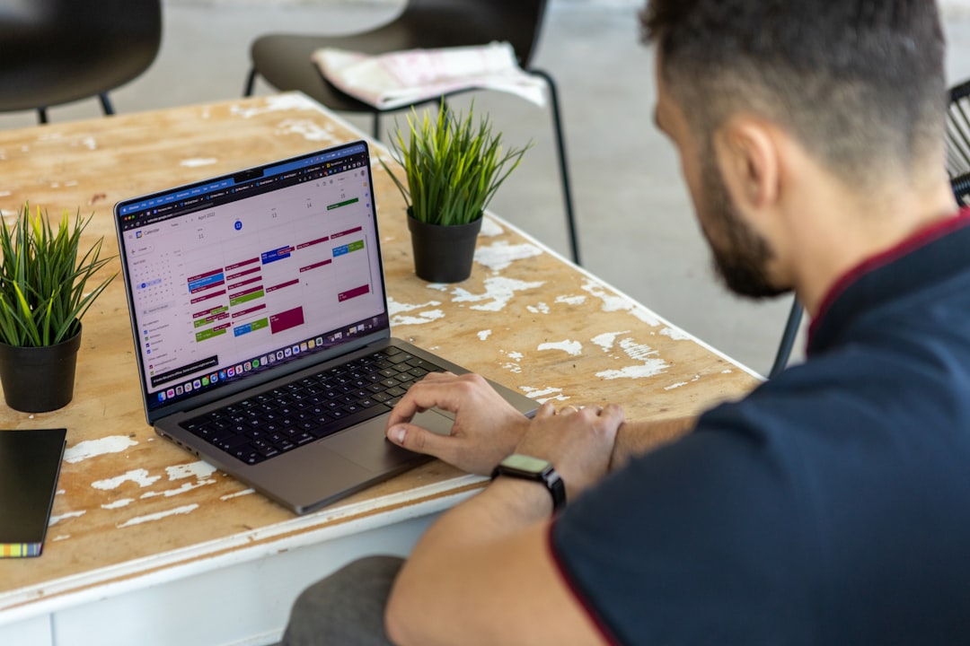 a man sitting at a table using a laptop computer email automation workflow, marketing funnel diagram, digital creator laptop workspace