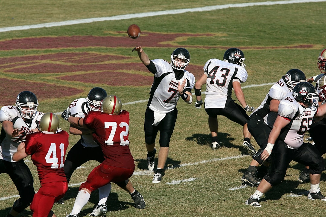 group of men playing football quarterback throwing pass under pressure, defensive linemen rushing, intense nfl action close up